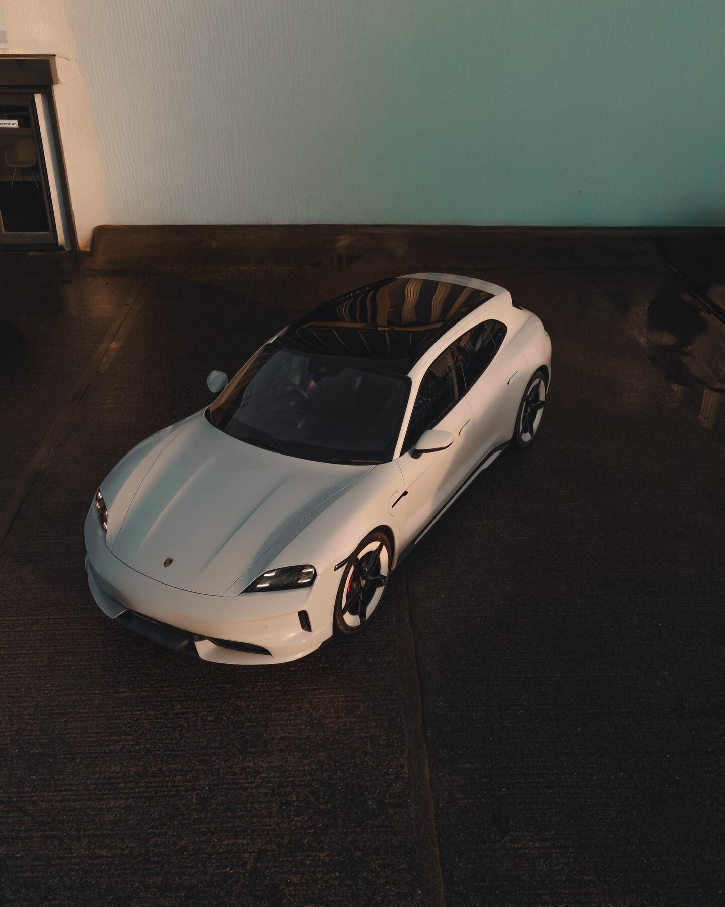 White Porsche Taycan aerial view with refurbished wheels