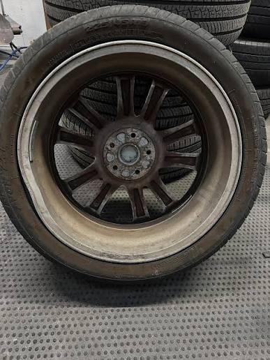 Wheel removed from car for professional straightening service